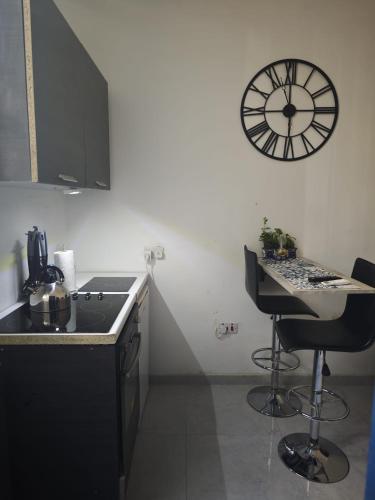 a kitchen with a counter and a clock on the wall at Hypogeum SuiteStudio in Ħal Saflieni