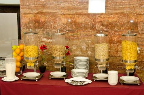 Una mesa cubierta con platos y recipientes de comida. en VIP Executive Entrecampos Hotel & Conference, en Lisboa