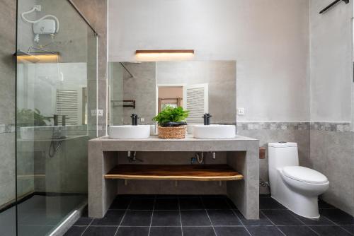 a bathroom with two sinks and a toilet at Samaya Boutique & Cuisine in Phnom Penh