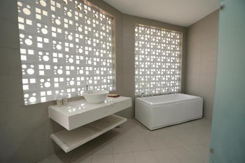 a white bathroom with a sink and a toilet at Blue Haven Resort Quy Nhơn in Quy Nhon