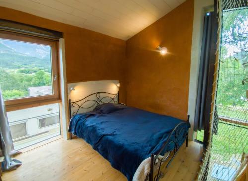 a bedroom with a bed in a room with a window at Au Son Du Diois in Die