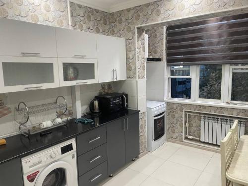a kitchen with a washer and dryer in it at Kvartira in Toshkent-Passajir Bekati