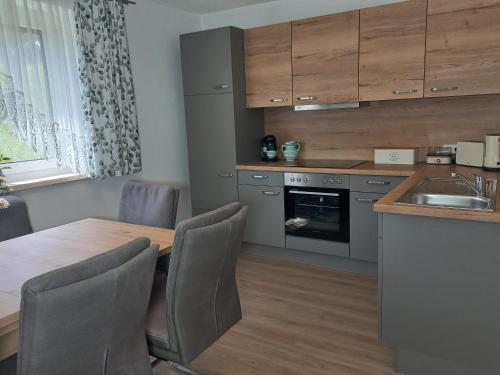a kitchen with a wooden table with chairs and a kitchen counter at Sweet Home Alpacas in Timelkam