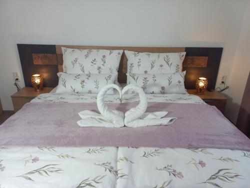two swans are forming a heart on a bed at Sweet Home Alpacas in Timelkam