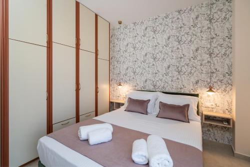 a bedroom with a large white bed with two towels at Fontana La Vista in Sitia