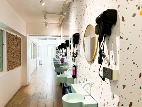 a row of sinks and mirrors in a bathroom at Easy Monday Pool Capsule Hotel - Old Town Bangkok in Bangkok