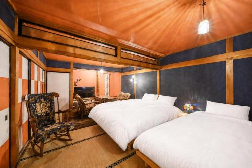 a bedroom with two beds and a table and a chair at とれるの【TORERUNO】 in Takayama