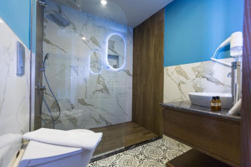 a bathroom with a shower and a toilet and a sink at Adella Beach Resort Hotel in Kuşadası