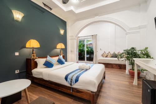 a bedroom with a king sized bed and a window at Samaya Boutique & Cuisine in Phnom Penh