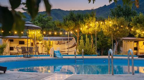 a resort pool with a table and chairs and a boat at Gapeyong Donghwa Caravan in Gapyeong