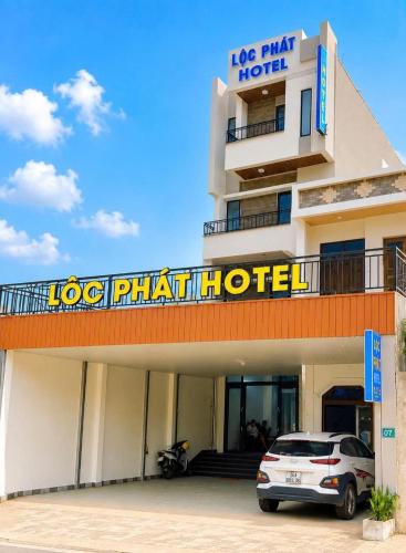 a hotel with a car parked in front of it at Lộc Phát Hotel Mộc Châu in Làng Môn
