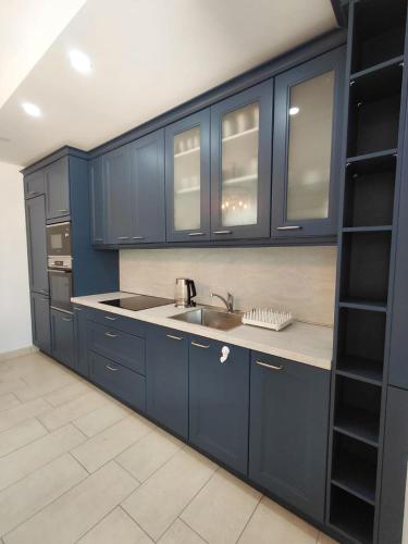 a kitchen with blue cabinets and a sink at Muo sea view Garden in Muo
