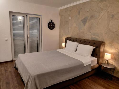 a bedroom with a large bed with a stone wall at Muo sea view Garden in Muo