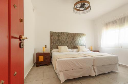 a bedroom with a large bed and a window at Cortijo Santa Cruz in Almuñécar