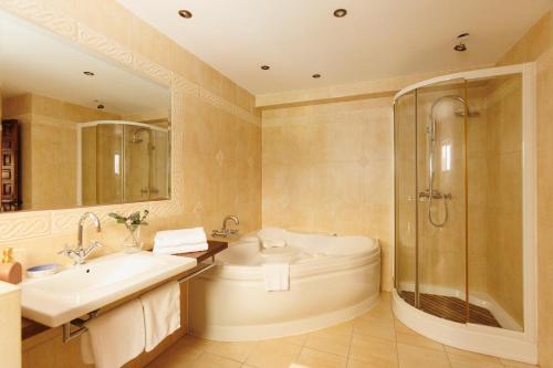 a bathroom with a tub and a sink and a shower at Cortijo Santa Cruz in Almuñécar