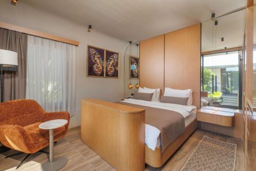 a bedroom with a bed and a chair and a window at Beach 222 Oludeniz in Oludeniz