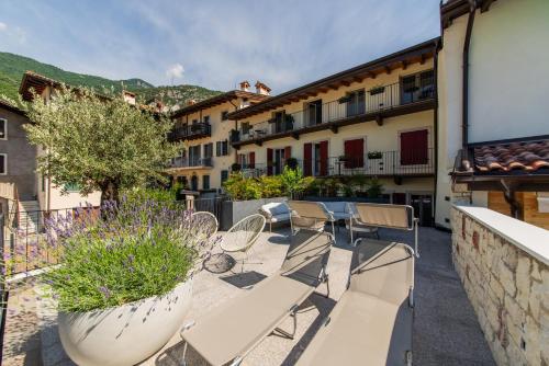 a patio with chairs and tables and buildings at HB Boutique Apartment in Arco