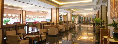 a dining room with chairs and tables in a restaurant at Chakungrao Riverview Hotel in Kamphaeng Phet