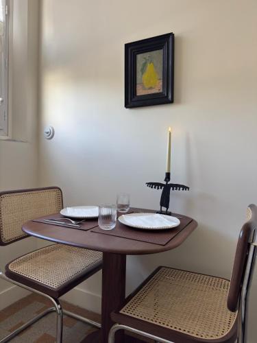 a dining room table with a candle on top of it at Superbe Appartement ultra-centre climatisé in Vernon