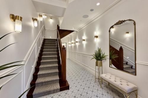 a hallway with a staircase and a mirror at Camden Hotel Suites in Camden