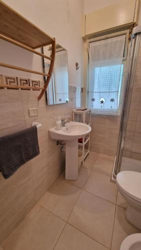 a bathroom with a sink and a toilet and a shower at Maison Etoile de Mer in Agnone Bagni