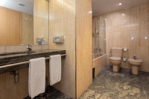 ein Badezimmer mit Toilette und Dusche sowie Handtüchern in der Unterkunft Hotel Nexta Escaldes in Andorra la Vella