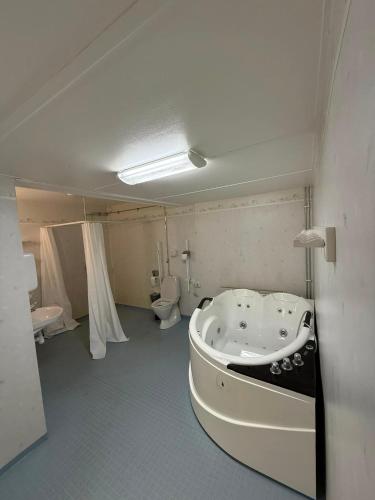 a bathroom with a bath tub and a toilet at Örkelljunga Hostel in Orkelljunga