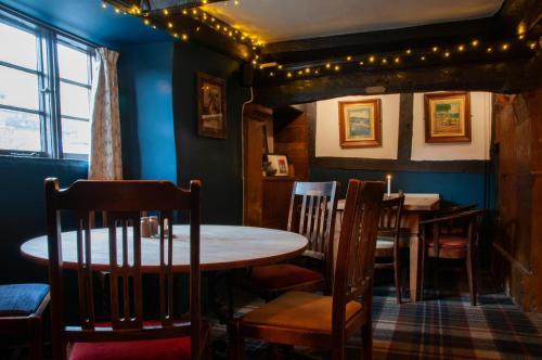 a dining room with a table and chairs at Mason's Arms in Montacute