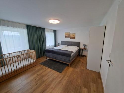 a bedroom with a bed and a crib in it at Ferienwohnung Wallersee in Neumarkt am Wallersee