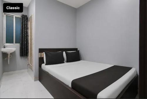 a bedroom with a bed and a bathroom with a sink at All sana guest house in Kolkata