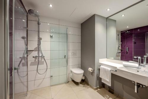 a bathroom with a shower and a toilet and a sink at Premier Inn Stuttgart Feuerbach in Stuttgart