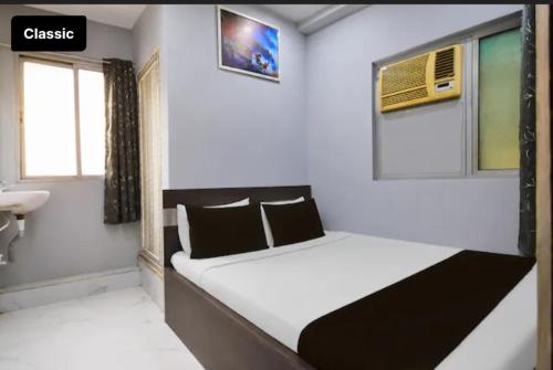 a small bedroom with a bed and a sink at All sana guest house in Kolkata
