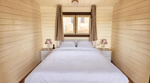 a bed in a small room with a window at The Heart Cabin בקתת הלב in Kidmat Tsvi