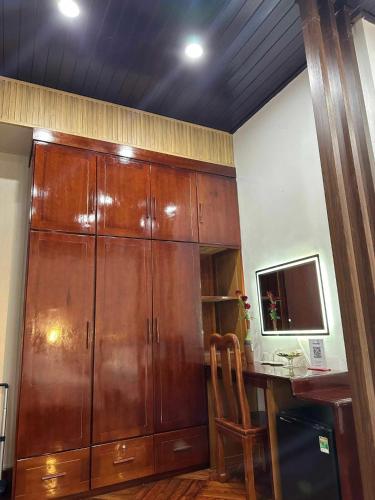 a large wooden cabinet in a room with a desk at Rose's Homestay Hue in Hue