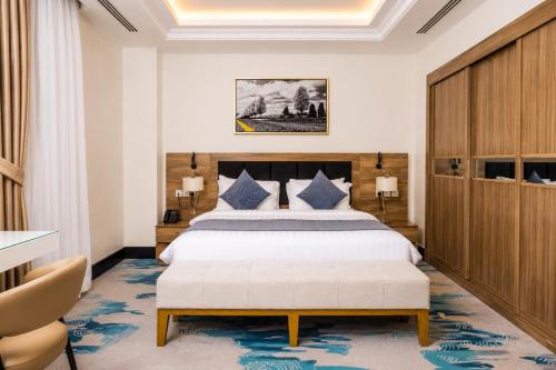 a bedroom with a large bed and a blue rug at The Proud Hotel Al Khobar in Al Khobar