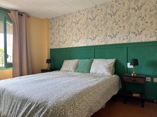 a bedroom with a bed with a green headboard at Oreneta in Fatarella