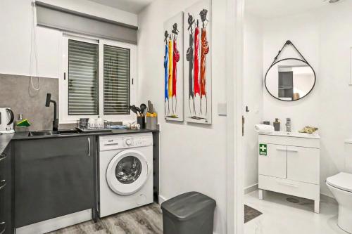 a bathroom with a washing machine and a sink at Lobo's House in Câmara de Lobos