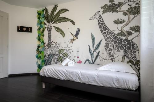 a bedroom with a bed with a mural of giraffes at Le Vogelgarten in Zellenberg