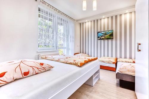 a bedroom with two beds and a window at WillaSimi in Władysławowo