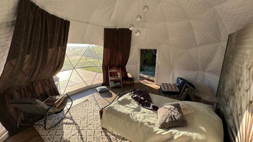 a bedroom with a bed and a large window at Saare Glamping Dome House in Salme