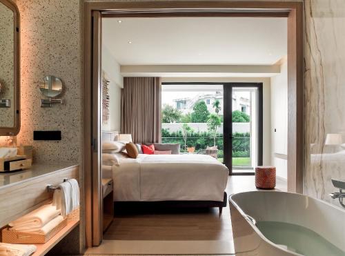 a bedroom with a bed and a bath tub and a bed at Chatrium Phuket Rawai in Rawai Beach