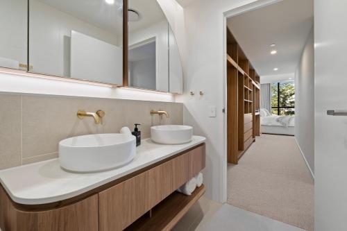 two sinks in a bathroom with a hallway at Luxury Esprit Apartment at Rainbow Bay in Gold Coast