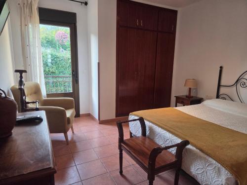 a bedroom with a bed and a chair and a window at El Secreto de Boada Spa privado & Restaurante Adults Only in Villamiel
