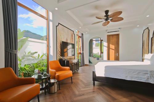 a bedroom with a bed and a tv and a chair at Pataco Tam Coc Hotel in Vũ Lâm