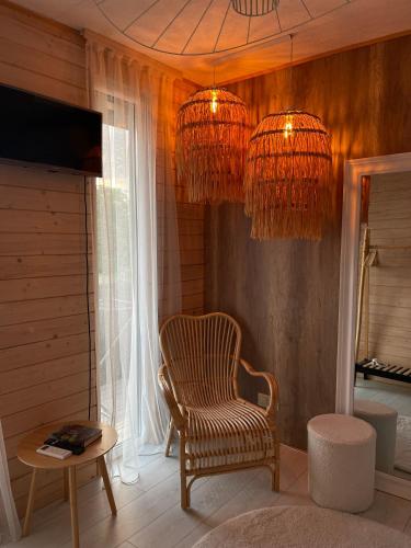 a living room with a chair and chandeliers at Vip Sadyba Svalyava in Svalyava