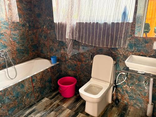 a bathroom with a toilet and a tub and a sink at Raiyar Resort doodhpathri in Rengazabal
