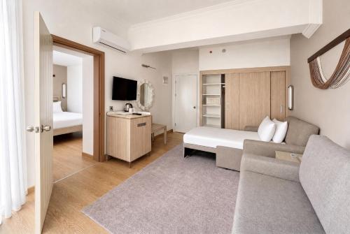 a bedroom with a bed and a couch in a room at Rai Foresta Tekirova & SPA in Kemer
