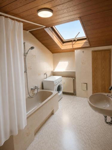 a bathroom with a tub and a sink and a window at Stay Offenbach in Bürgel