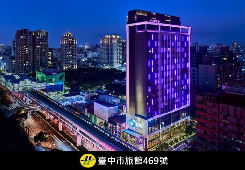 a building with purple lights on it in a city at Moxy Taichung in Taichung