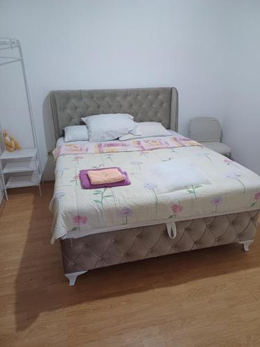 a bed in a bedroom with a white wall at Apartman Miljan in Trebinje